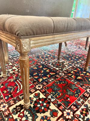 un banc sur lequel est posé un coussin, posé à son tour sur un tapis