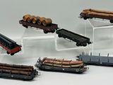 cinq types différents de wagons transportant des grumes