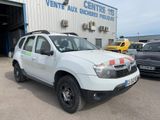 une photo d'une Dacia blanche garée devant un immeuble