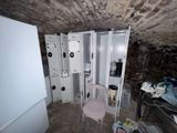 an image of a room with a refrigerator and a chair in it