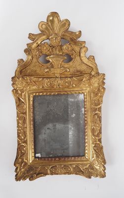 une image d'un miroir encadré d'or accroché à un mur
