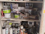 a cabinet full of paint and other items in the room