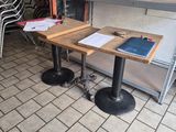 tables and chairs in a restaurant with a chalk board on the wall