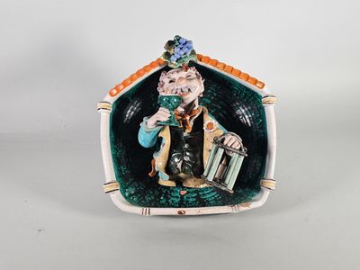 Plat décoratif en barbotine figurant en fort relief un homme…