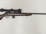 Le fusil est posé par terre, près du mur.