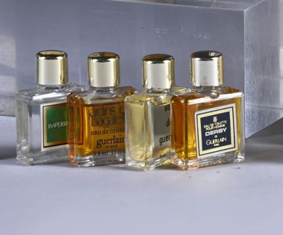 five bottles of perfume sitting on a table next to each other
