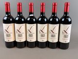 six bottles of red wine are lined up in a row