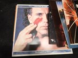 three dvds on a table with a man holding a red heart