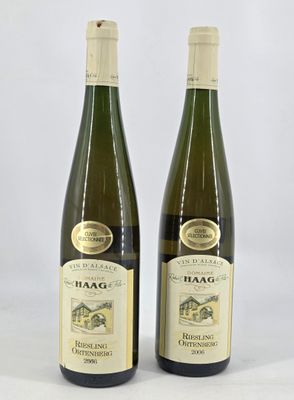 two bottles of wine sitting next to each other on a white surface