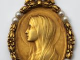 un gros plan d'une médaille d'or représentant le visage d'une femme