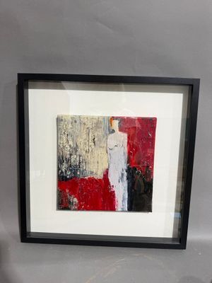 tableau encadré représentant une peinture abstraite rouge et blanche dans un cadre noir