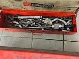 une boîte à outils rouge remplie d'outils, posée sur un sol carrelé
