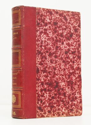 un vieux livre à la couverture rouge posé sur une surface blanche