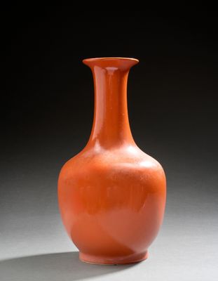 un vase orange posé sur une table