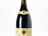 une bouteille de vin posée sur une table blanche