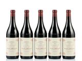 quatre bouteilles de vin sont alignées sur une surface blanche