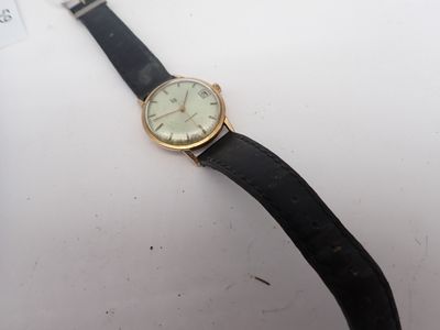une photo d'une montre posée sur une surface blanche