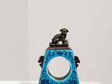 une horloge bleue posée sur un socle blanc dans une pièce