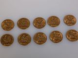 a close up of a bunch of gold coins on a white surface