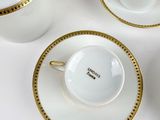 four cups and saucers on a white table