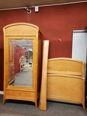 deux lits en bois et un miroir dans une chambre