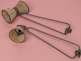 three old fashioned metal objects on a pink surface