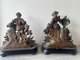 pair of bronze figurines of a woman and a boy with a basket of flowers