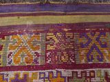 a close up of a colorful rug with a cat on it
