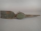 an old knife with a green handle sitting on top of a table