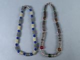 paire de colliers composés de perles multicolores sur un fond blanc