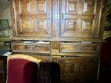 an old wooden cabinet with a red chair in front of it