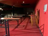 des tables et des chaises dans une pièce aux murs rouges et à la moquette rouge