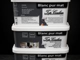 trois seaux de peinture blanche posés sur une table
