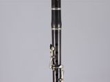a close up of a black and silver clarinet on a clear surface