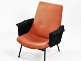 une chaise orange et noire posée sur une surface blanche, avec un fond blanc
