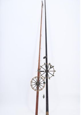 une paire de cannes à pêche anciennes surmontées d'un moulinet
