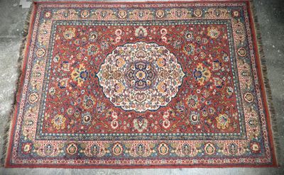a red rug with a medallion design on it sitting on a cement floor