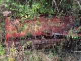 an old red truck that is sitting in the grass