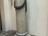 une colonne en pierre sur laquelle est enroulée une corde, dans une pièce