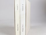 two books are stacked on top of each other on a white surface