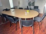a table with chairs and a laptop on it in a room