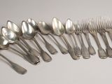 huit cuillères et six fourchettes en métal argenté, disposées en rangée