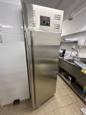 un grand réfrigérateur en acier inoxydable dans une cuisine professionnelle