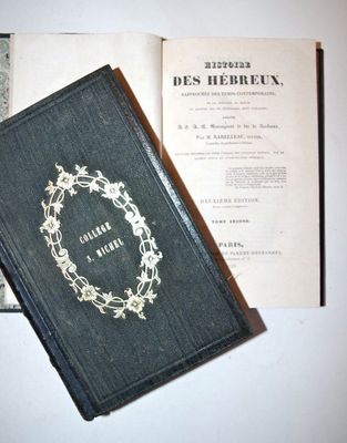 an old book with a wreath on it sitting on a table