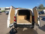 the back of a white van with its doors open in a parking lot