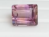 a close up of a pink tourmaline gemstone on a white surface