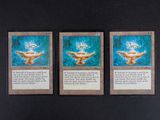 trois cartes de jeu de cartes magiques posées sur une surface noire