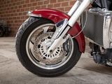 a red motorcycle parked in front of a brick wall