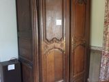 une grande armoire en bois dans le coin d'une pièce