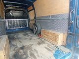 a blue van with a lot of wood in the back